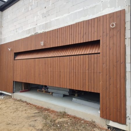 Brama garażowa fasadowa zlicowana z elewacją z thermo sosny. brama garażowa fasadowa w elewacji brama garażowa elewacja drewniana Pracownia Stolarska Latzke